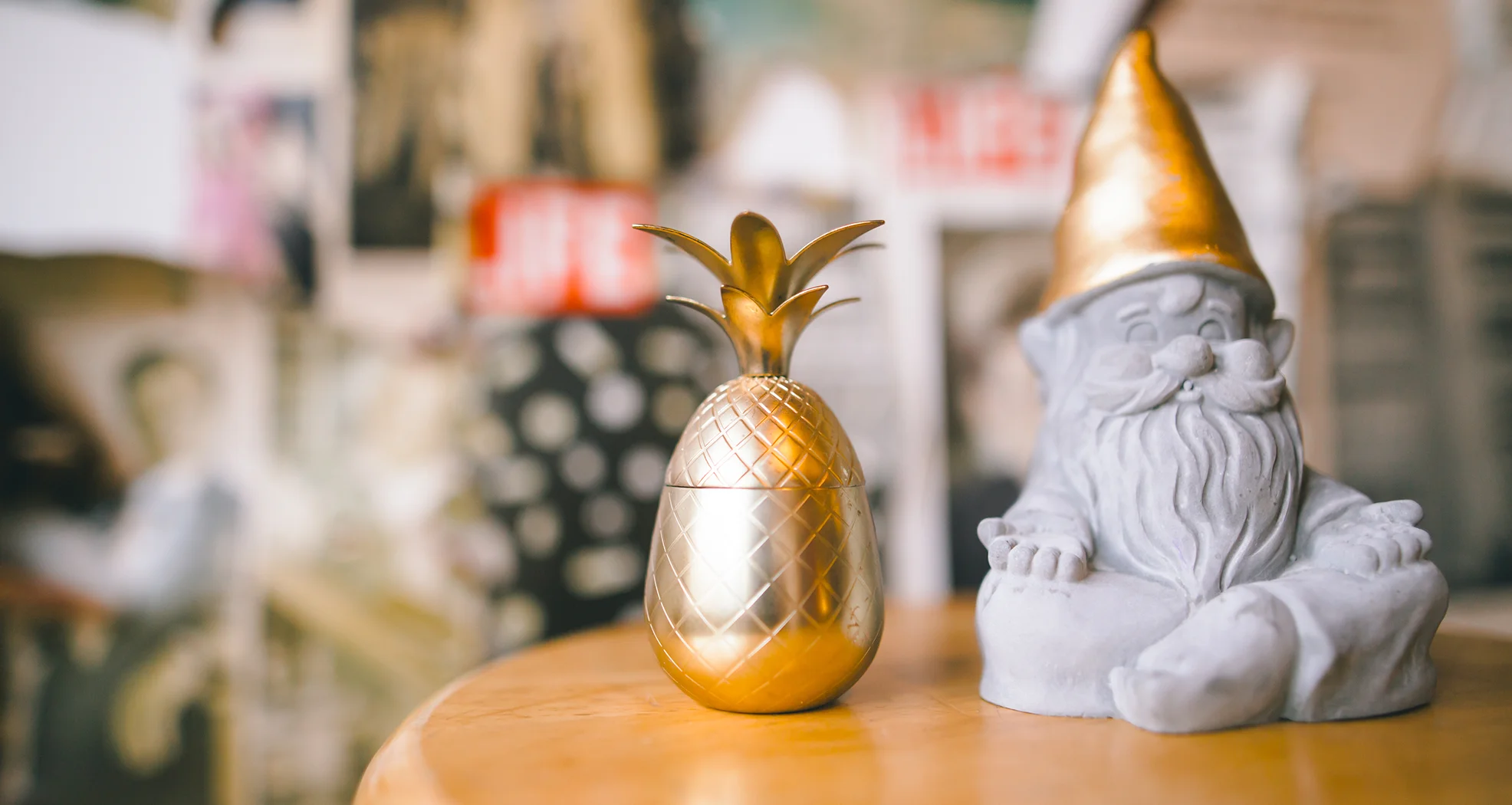 A golden pineapple and a gnome sit next to each other
